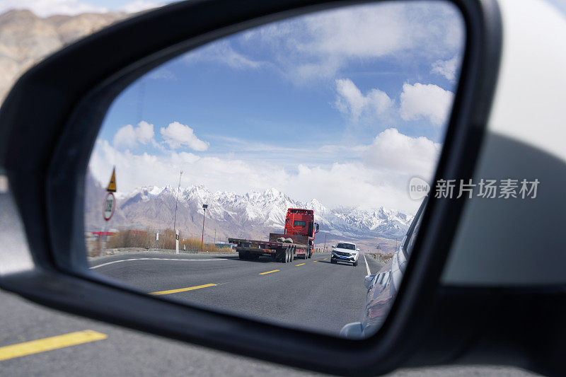 雪山背景公路位于帕米尔山区，空旷的柏油路配雪山