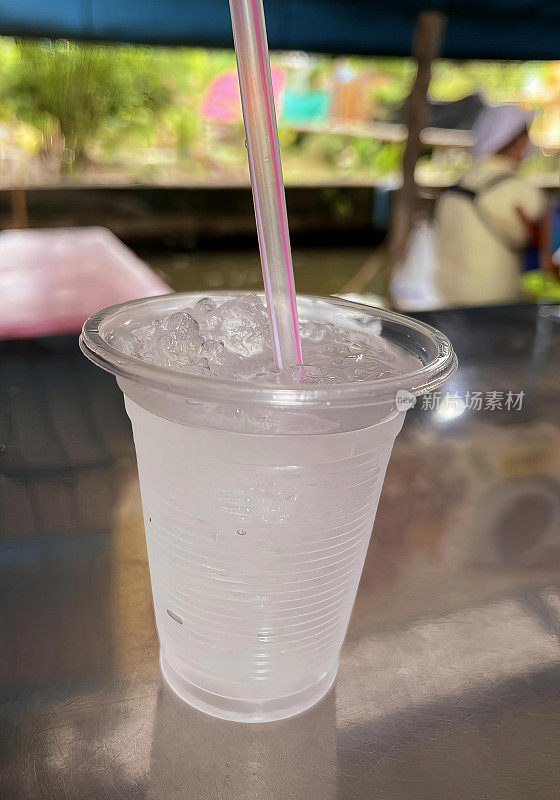 一张带有一根吸管和一根粉色吸管的塑料杯的照片，用一根吸管和一根粉色吸管的塑料杯喝蛋奶酒。