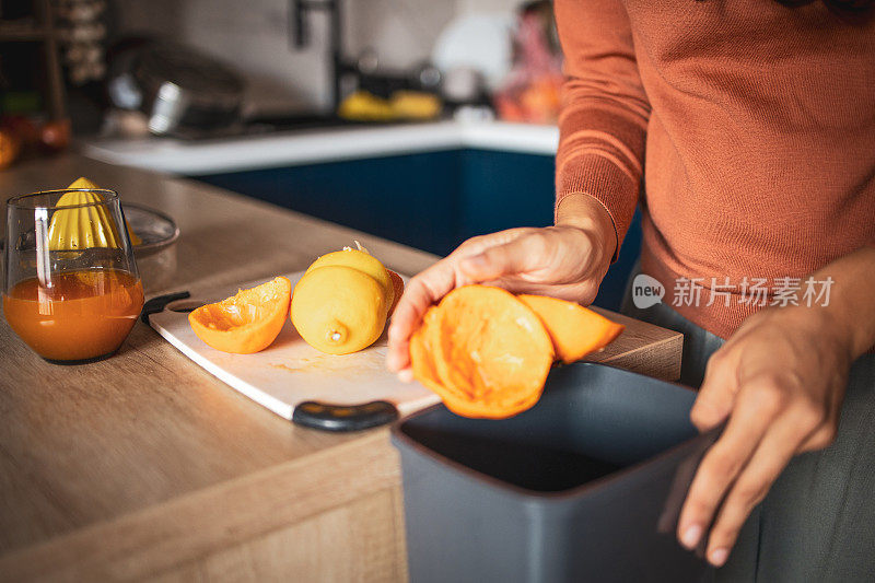 一个西班牙裔黑发女人在厨房准备橙汁的特写