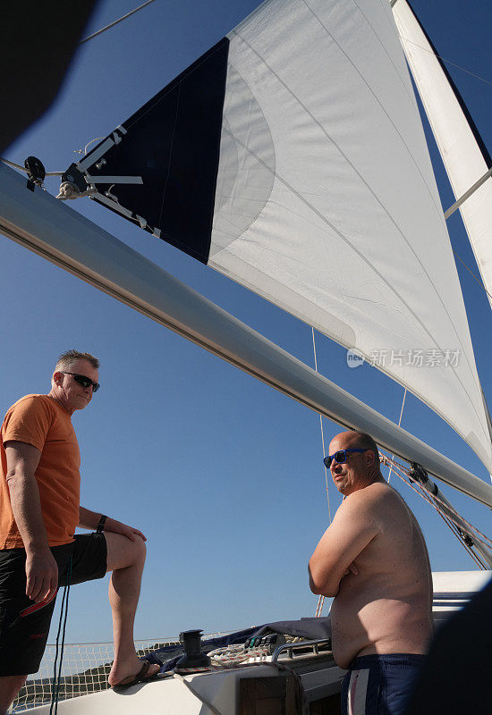 两个人在帆船上，在克罗地亚的亚得里亚海上，像听着海上交响乐一样航行。