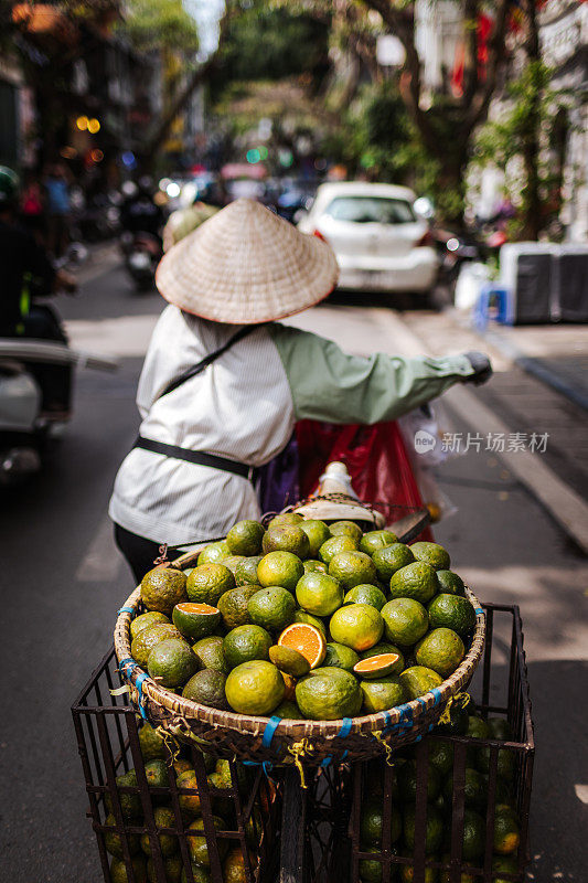 传统越南街头小贩售卖新鲜橙子