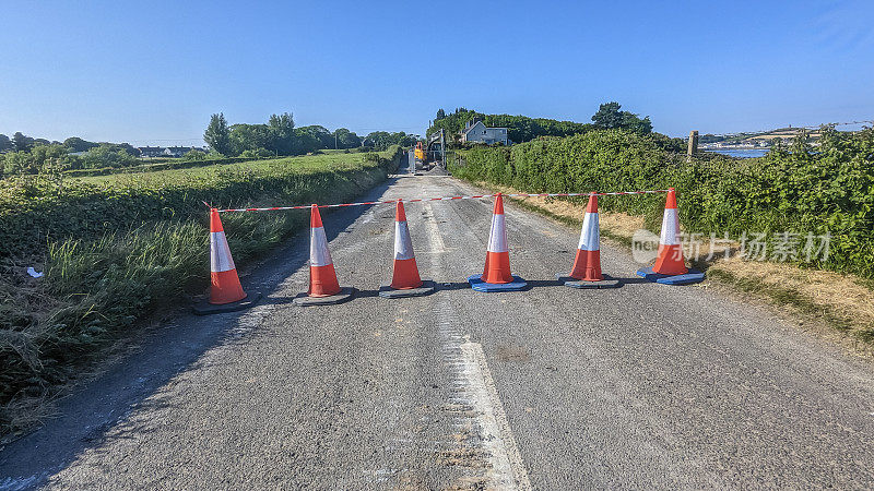 道路工程完成时，交通锥阻塞了一条乡村道路。