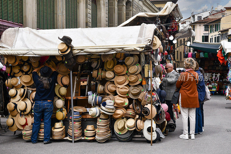 意大利托斯卡纳佛罗伦萨中央市场广场圣洛伦佐历史悠久的街头市场上，一个卖草帽的小摊