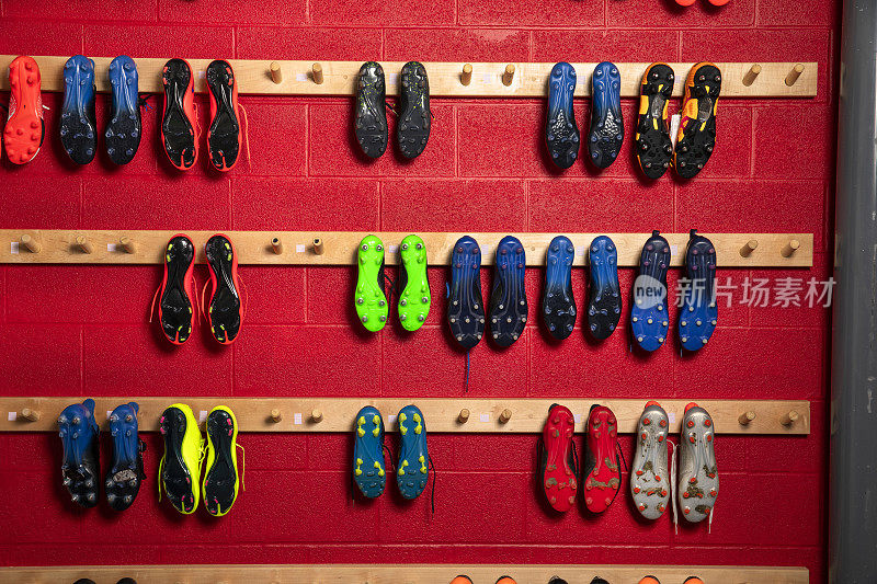 足球运动员的球鞋挂在体育馆更衣室的墙上