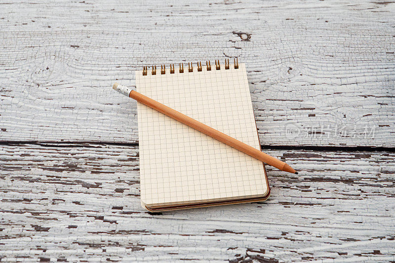 空白笔记本与铅笔在白色木制背景。笔记和教育概念库存照片