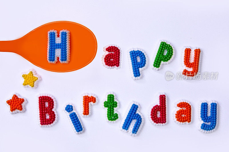 生日快乐，用五颜六色的糖字母和一个橘子勺子写的