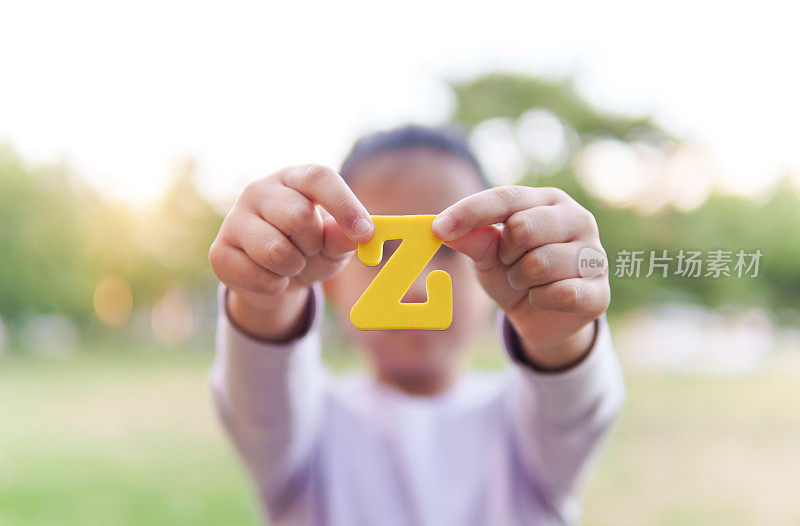 小孩拿着字母“Z”