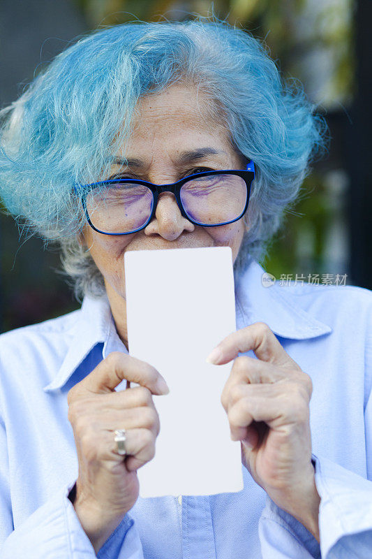 微笑惊讶的泰国老年妇女看着中奖彩票
