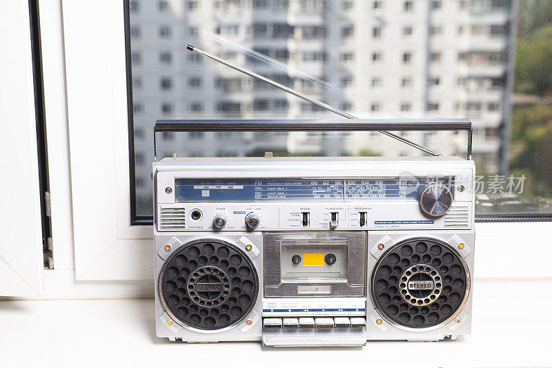 窗台上放着80年代的银色复古贫民窟收音机盒式录音机