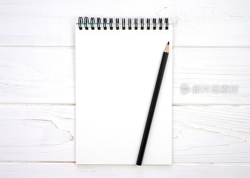 一个空白的笔记本和一支铅笔在一个白色的木制背景上。Flatlay组成。模型。前视图。副本的空间。