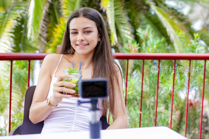 坐在户外露台上记录博客的年轻女子