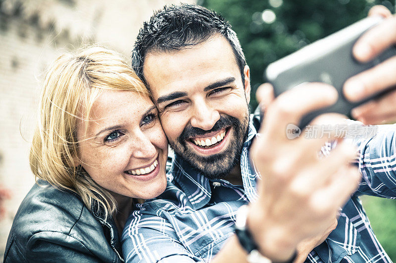 30岁快乐情侣用智能手机拍照
