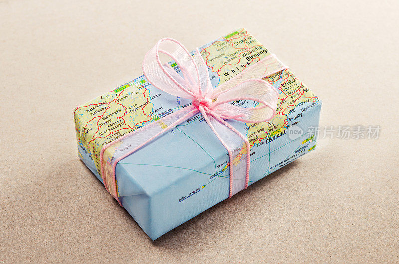 一份用地图纸和粉色蝴蝶结包装的一路平安礼物
