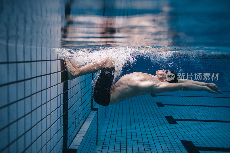 职业男性游泳运动员在游泳池内的行动