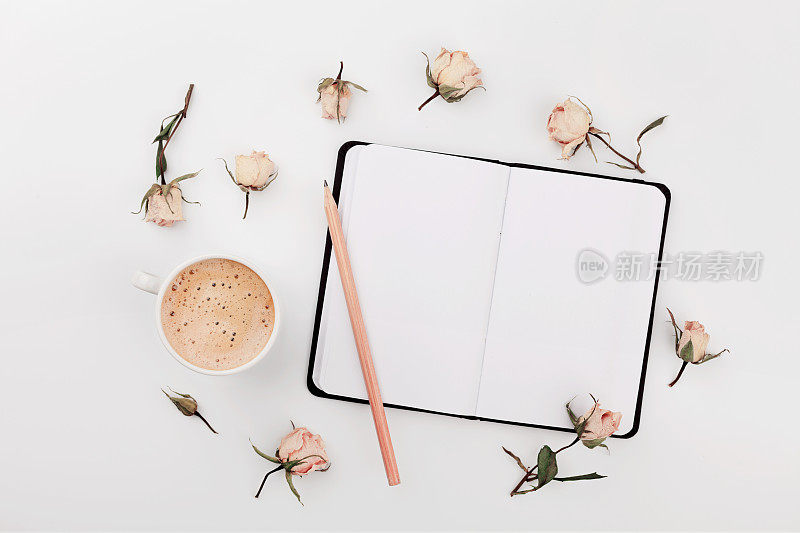 咖啡，空笔记本，干玫瑰花。温馨的早餐。平的。