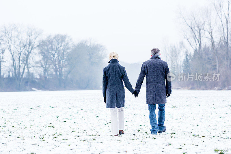 一对老年夫妇正在进行冬季散步