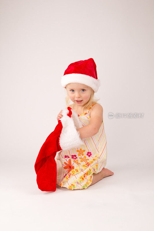 戴着圣诞老人帽和圣诞袜的小女孩