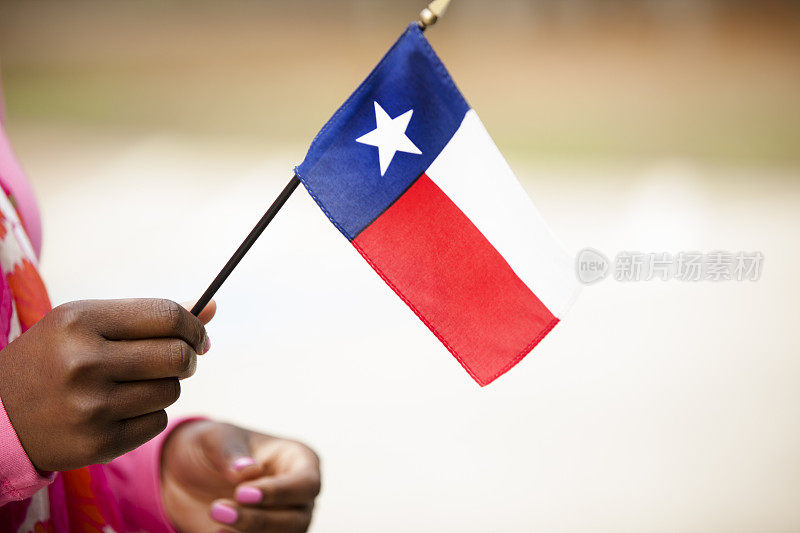 非洲裔妇女举着美国德克萨斯州的国旗。
