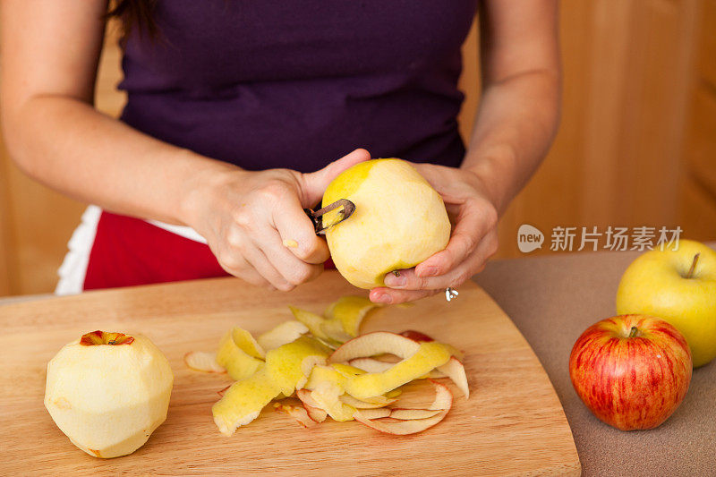 年轻女子在家厨房削苹果