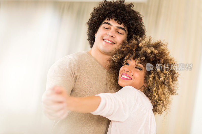 年轻相爱的夫妇一边跳舞一边享受。