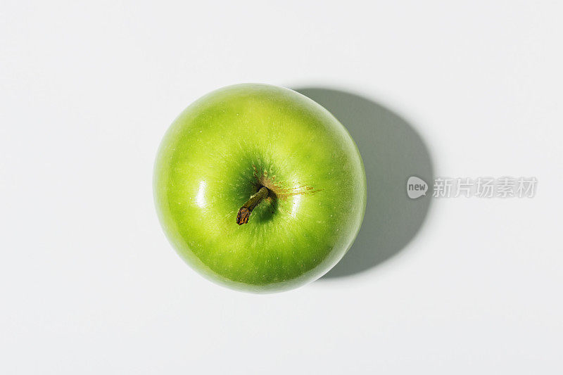 青苹果与白苹果的对比有强烈的阴影。