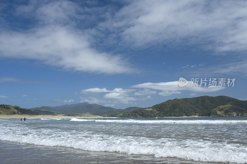 在晴朗的天空下，海浪轻轻地撞击着海滩。