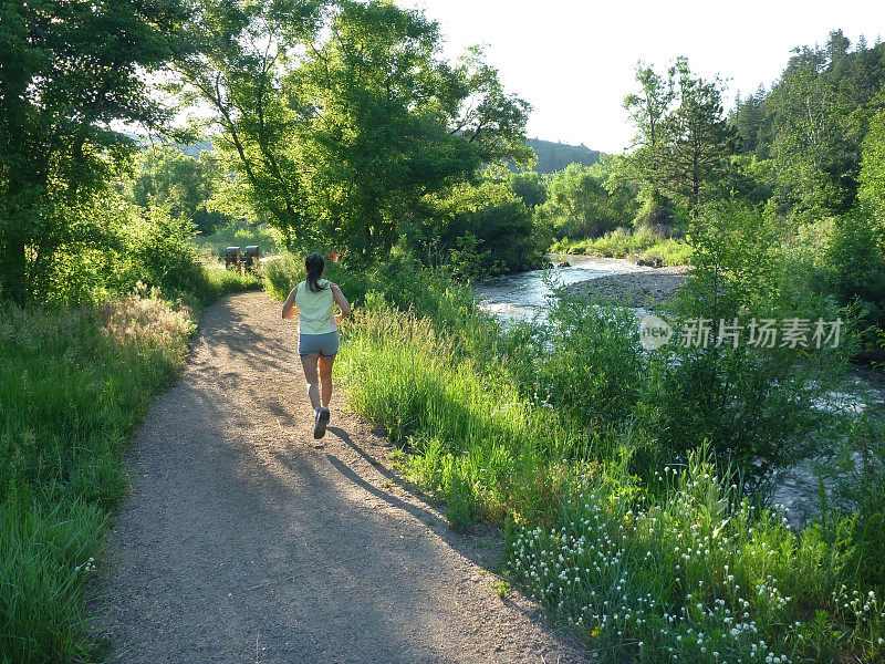 年轻女子在科罗拉多落基山脉的熊溪河上奔跑