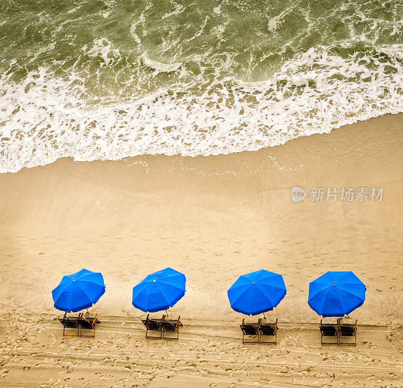 沙滩椅、雨伞和海浪