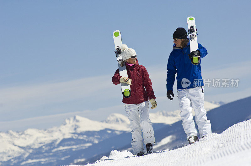 以高山为背景的滑雪者在散步和交谈