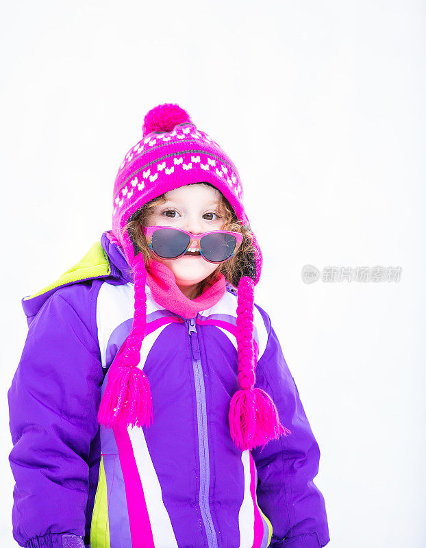 戴着太阳镜的小女孩在外面玩冬天的雪