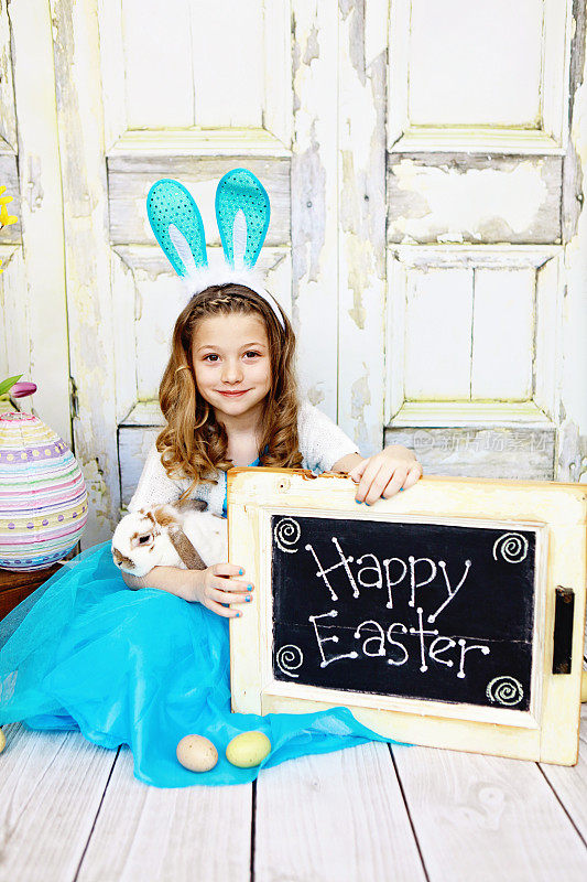 带着兔子和“复活节快乐”标志的女孩