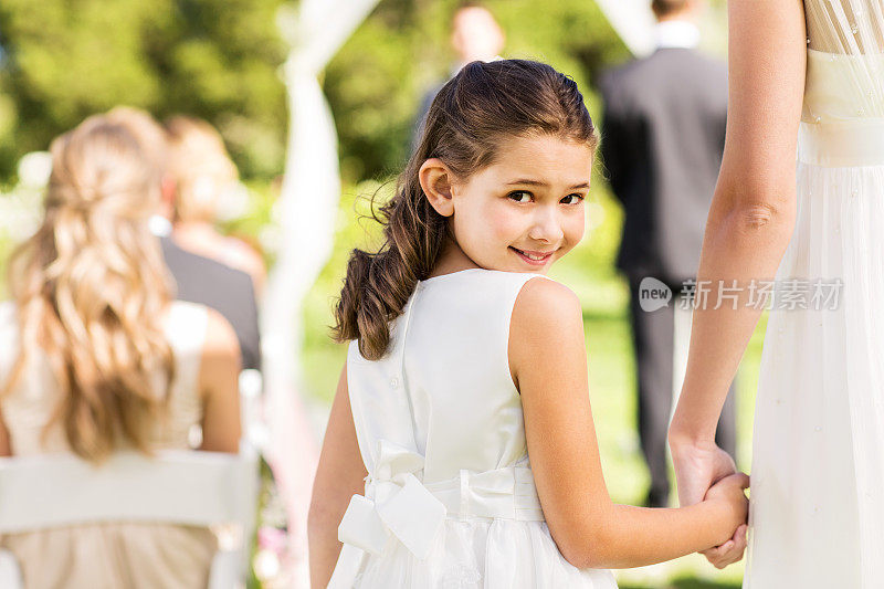 户外婚礼上，花童牵着新娘的手