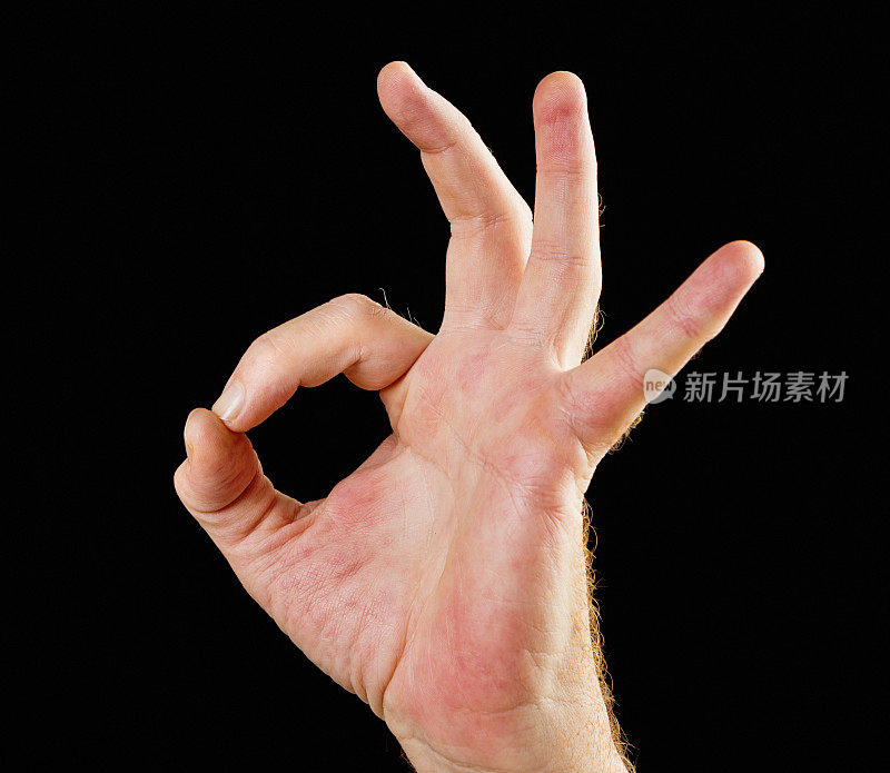 手势:男性在黑色背景下做出“OK”的手势