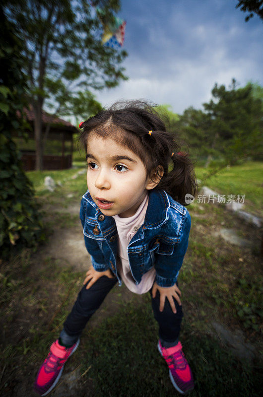 广角近距离拍摄的高加索幼童女孩在外面做鬼脸