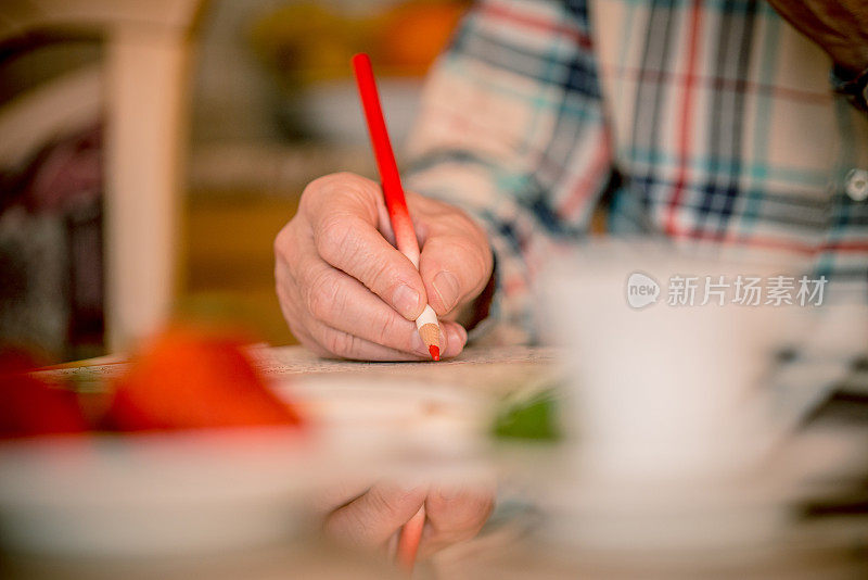 特写的高级男子涂色书在家里，欧洲