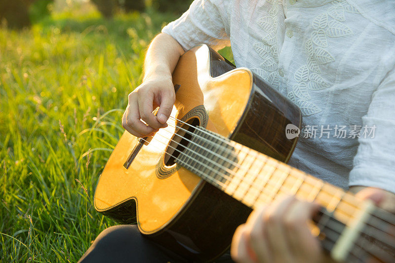 一个人坐在草地上弹吉他