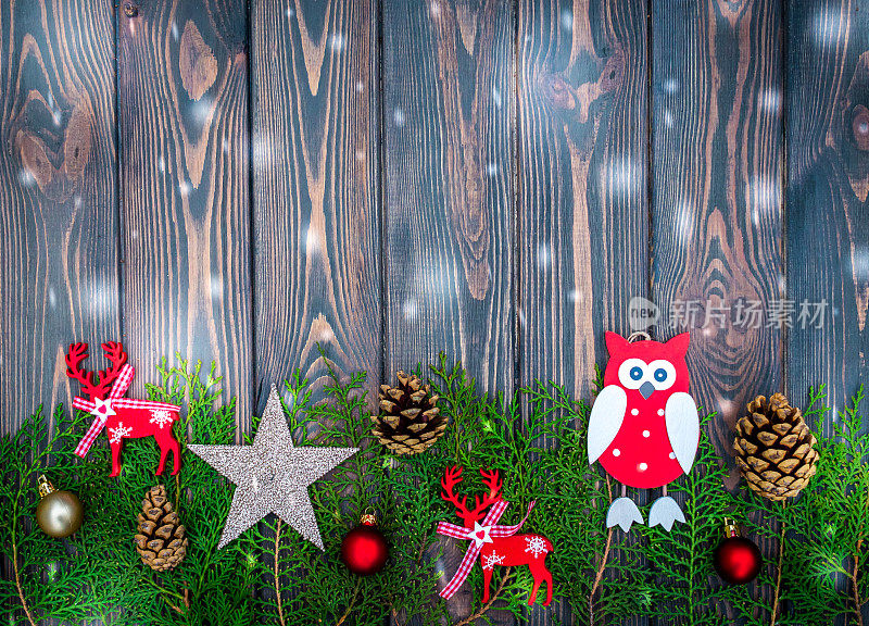 新年贺卡。圣诞玩具和针在旧木头的背景上