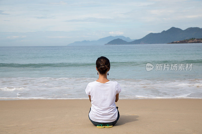 美丽的女人注视着平静的大海。