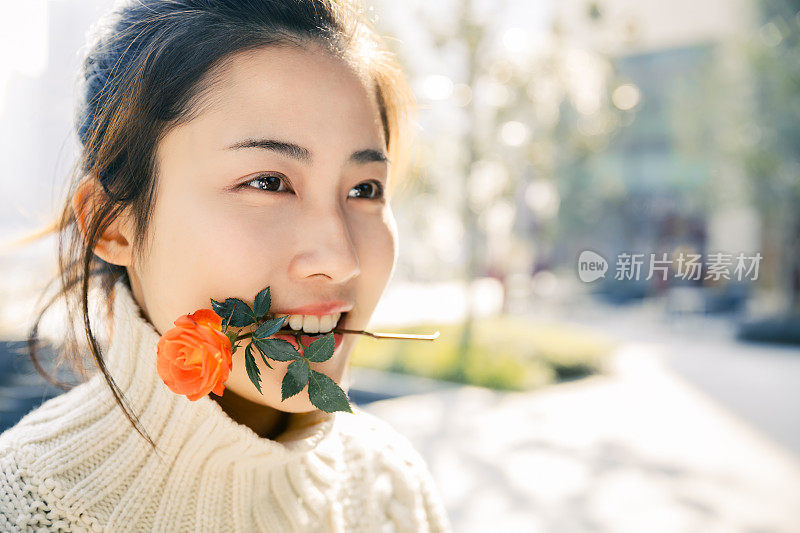 亚洲女孩在太阳耀斑下的红花，上海，中国