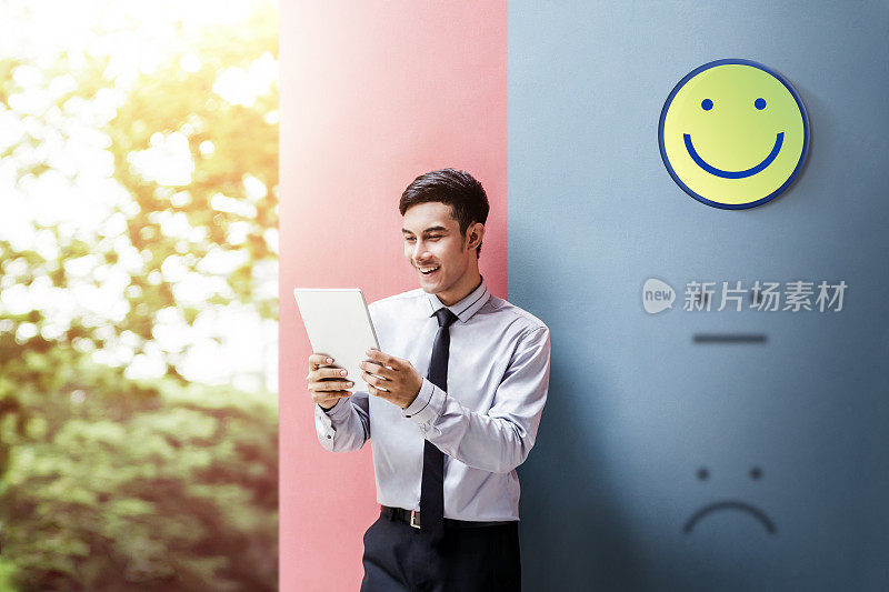 客户体验概念，快乐的商人享受在数字平板电脑与笑脸评分的满意度调查