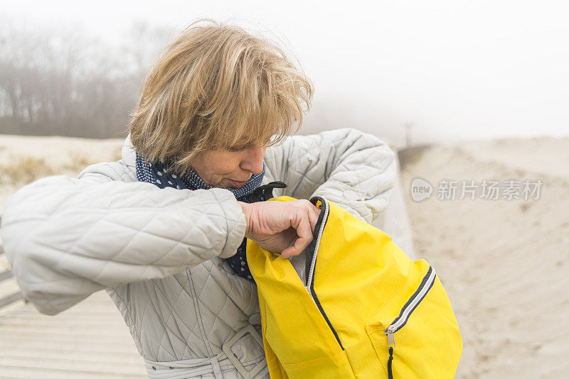 这是一个迷人的，快乐的，成熟的50岁女人在海滩上的肖像