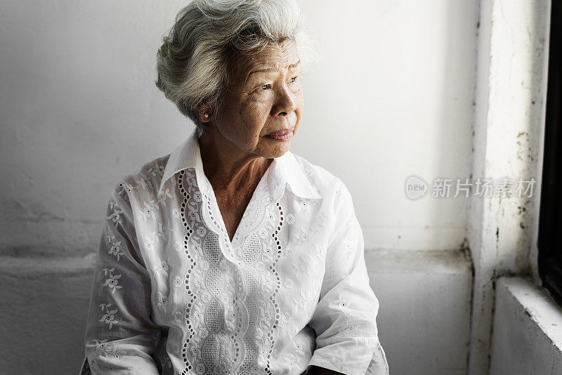 侧面的年长亚洲妇女与深思的脸表情