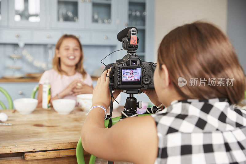 女孩在厨房为她的朋友拍摄烹饪视频博客