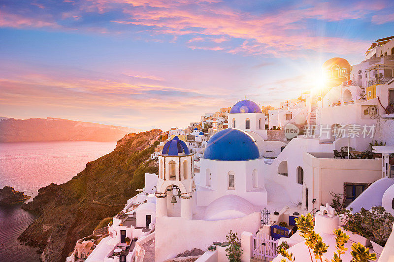 希腊圣托里尼岛蓝色圆顶教堂的日落景色