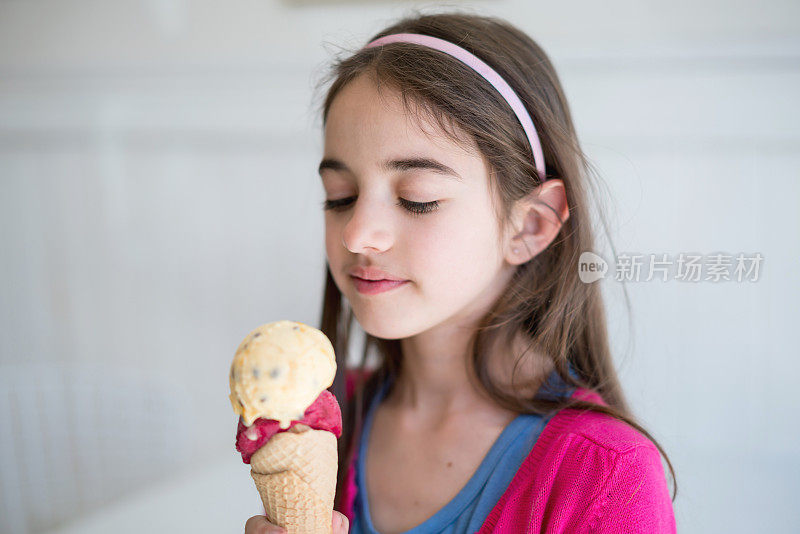 美丽的小女孩看着她的冰淇淋很忧郁