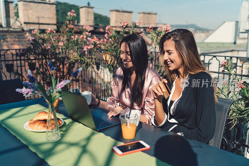 女人在阳台上吃早餐，在网上购物