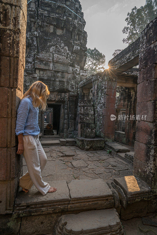 女游客漫游在古老的寺庙日落享受发现和旅游在亚洲，柬埔寨吴哥窟