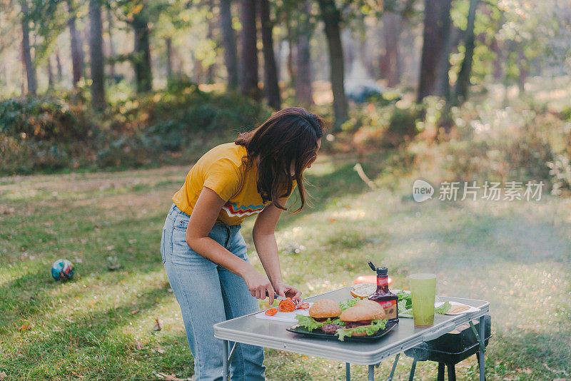 在森林里做烧烤汉堡的女人