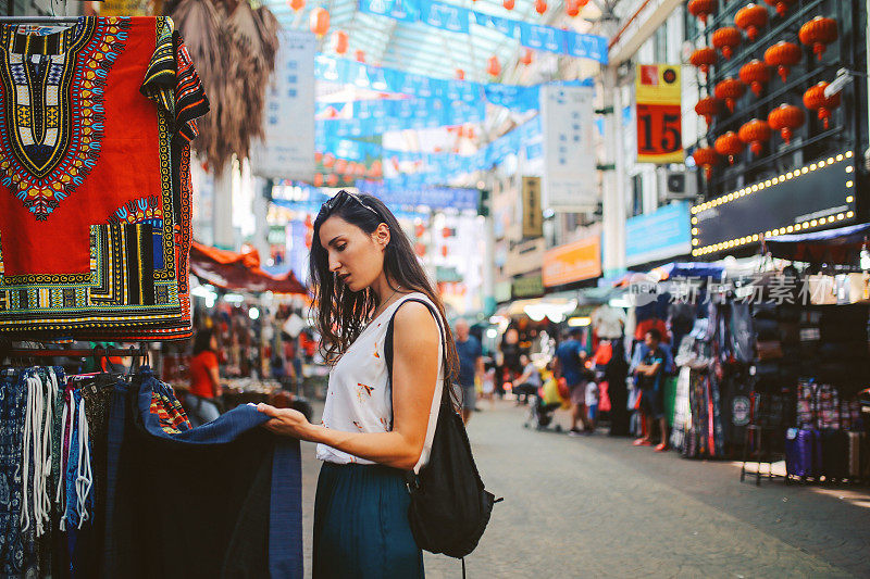 年轻的旅行者女人在吉隆坡唐人街区购物