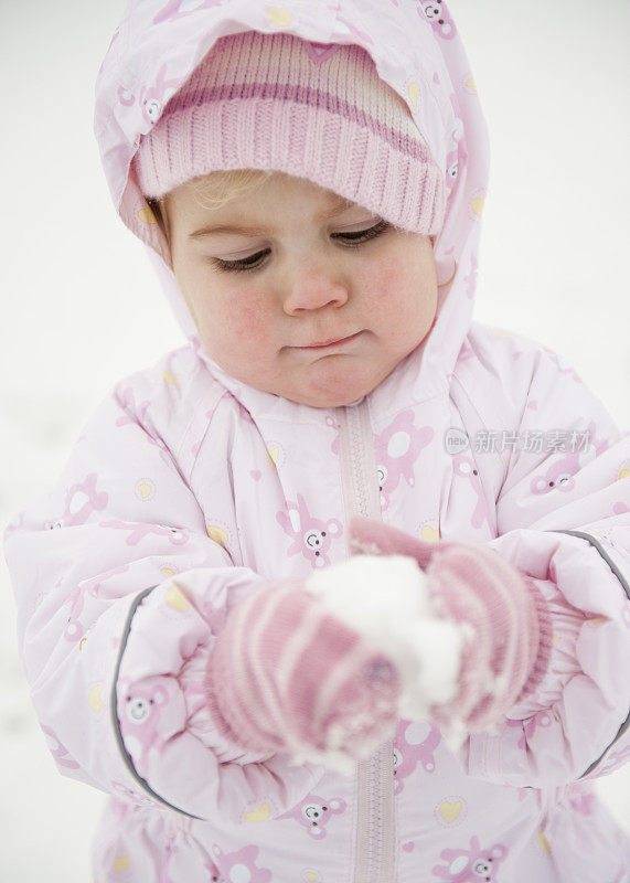 正面的金发小女孩玩雪雪球